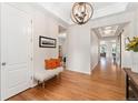 Bright foyer featuring hardwood floors, a decorative light fixture, and a charming bench with orange pillows at 6046 Gilbert Way, Golden, CO 80403