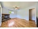 Spacious living room featuring hardwood floors, a stone fireplace, and a ceiling fan at 1750 S Dale Ct, Denver, CO 80219