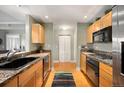 Bright kitchen with wood cabinets, granite countertops, stainless steel appliances at 300 W 11Th Ave # 15F, Denver, CO 80204
