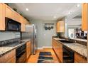 Bright kitchen with wood cabinets, granite countertops, and stainless-steel appliances at 300 W 11Th Ave # 15F, Denver, CO 80204