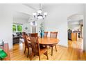 Well-lit dining room with hardwood floors, an elegant chandelier, and an archway leading to the kitchen at 1205 W 11Th Ct, Broomfield, CO 80020
