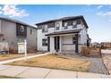 Charming two-story home featuring a covered front porch and modern gray and white color scheme at 10661 Reunion Pkwy, Commerce City, CO 80022
