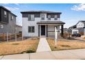 Charming two-story home featuring a covered front porch and modern gray and white color scheme at 10661 Reunion Pkwy, Commerce City, CO 80022