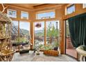 Bright sunroom with slate floors, multiple windows, and scenic outdoor views at 1575 York Gulch Rd, Idaho Springs, CO 80452