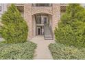 The condominium's entryway with stone archway and well-maintained landscaping at 7292 S Blackhawk St # 2-204, Englewood, CO 80112
