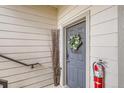 Gray front door with a decorative wreath, a seasonal floral arrangement and safety equipment at 7292 S Blackhawk St # 2-204, Englewood, CO 80112