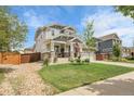 Charming two-story home featuring a landscaped yard, inviting front porch, and a well-maintained lawn at 484 N Jamestown Way, Aurora, CO 80018