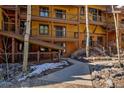 Multi-level condo with wooden balconies, natural landscaping, and a stone walkway leading to the entrance at 820 Columbine Rd # 10, Breckenridge, CO 80424