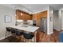 Modern kitchen featuring sleek wood cabinets, stainless steel appliances, and a stylish island with bar seating at 4200 W 17Th Ave # 621, Denver, CO 80204
