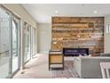 Bright living room with sliding glass doors, hardwood floors, modern fireplace, and unique wood accent wall at 15525 W La Salle Ave, Lakewood, CO 80228