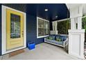 Cozy front porch features a swing and a vibrant yellow door, adding a pop of color to the home's entrance at 3644 Wabash St, Denver, CO 80238