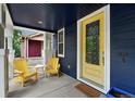 Relaxing front porch with yellow chairs and a small table provides a perfect spot for morning coffee at 3644 Wabash St, Denver, CO 80238