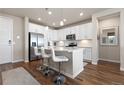 Modern kitchen with white cabinets, stainless steel appliances, a breakfast bar, and wood floors providing a welcoming culinary space at 420 E Fremont Pl # 309, Centennial, CO 80122