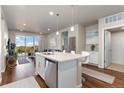 Modern kitchen with white cabinetry and a breakfast bar that leads to the spacious living area and balcony at 420 E Fremont Pl # 309, Centennial, CO 80122