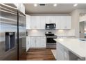 Well-lit kitchen features white cabinets, stainless steel appliances, subway tile backsplash, and generous counter space at 420 E Fremont Pl # 309, Centennial, CO 80122