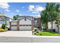 Inviting two-story home featuring a three-car garage, brick accents, and well-manicured landscaping at 18126 E Alamo Dr, Centennial, CO 80015