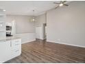 Open-concept living room with high ceilings, hardwood floors, and modern light fixture at 4762 S Clay Ct, Englewood, CO 80110