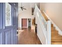 Bright entryway showcasing hardwood floors, a staircase, and an open view into the living space at 8300 Fairmount Dr # J105, Denver, CO 80247
