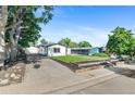 Well-maintained home featuring an expansive driveway, lush trees, and manicured front lawn at 5640 Niagara St, Commerce City, CO 80022