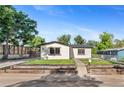 Attractive home with a well-kept lawn, modern accents, and a welcoming front entrance at 5640 Niagara St, Commerce City, CO 80022
