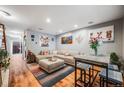 Bright living room with a large sectional sofa, unique artwork, hardwood floors, and a stylish accent rug at 1150 Inca St # 43, Denver, CO 80204