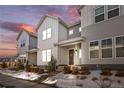 Charming modern home with beautiful gray siding, front porch, winter foliage, and stunning sunset backdrop at 8055 Navajo River Loop # B, Littleton, CO 80125