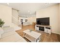 Open-concept living room features a fireplace and views of the modern eat-in kitchen at 8055 Navajo River Loop # B, Littleton, CO 80125