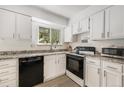 Bright kitchen with white cabinets, granite countertops and modern black appliances at 10142 S Turkey Creek Rd, Morrison, CO 80465
