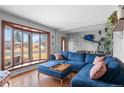 Inviting living room features hardwood floors, a large bay window, and stylish blue sectional at 1526 S Elm St, Denver, CO 80222