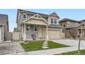 Two-story home featuring gray siding, a manicured lawn, a driveway, and an attached two-car garage at 18263 E 52Nd Ave, Denver, CO 80249