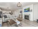 Cozy living room showcasing a fireplace with white mantel, wood floors, and sofas at 12513 Shore Point St, Firestone, CO 80504
