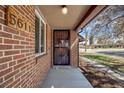 Inviting front entrance featuring a brick exterior and secure screen door, creating a warm and welcoming approach to the home at 5611 E 13Th Ave, Denver, CO 80220