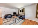 Bright living room featuring hardwood floors, a large window, and comfortable seating arrangement perfect for relaxation at 5611 E 13Th Ave, Denver, CO 80220