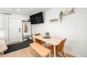Cozy dining area with modern table and seating, adjacent to the entrance and featuring minimalist decor and ample light at 7450 Granada Rd, Denver, CO 80221