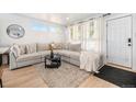 Bright and airy living room with a large sectional sofa, plush rug, and abundant natural light from multiple windows at 7450 Granada Rd, Denver, CO 80221
