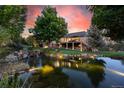 Scenic backyard view with a tranquil pond and stone waterfall feature, creating a serene outdoor space at 10145 Meadow Run, Parker, CO 80134