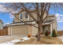 Two-story home with a two-car garage, featuring a blend of brick and siding, with a mature tree in the yard at 7768 Xavier Ct, Westminster, CO 80030