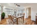 Sunlit dining area with hardwood floors and a table set for dinner, seamlessly flowing into the living room at 1548 Ulster St, Denver, CO 80220