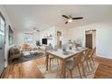 Bright open-concept dining room with hardwood floors and modern ceiling fan and furniture at 1548 Ulster St, Denver, CO 80220