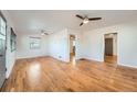 Spacious living room featuring gleaming hardwood floors and ceiling fan at 1548 Ulster St, Denver, CO 80220