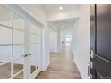 Bright hallway with light wood flooring and French doors that bring lots of natural light to the home at 14155 Bunny Hop Ln, Parker, CO 80134
