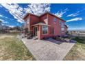 Expansive backyard of a two-story home featuring a brick patio with seating and a well-maintained lawn at 21606 E Idyllwilde Dr, Parker, CO 80138