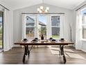 Bright dining area with large windows, a chandelier, and a stylish wooden table with seating for six at 1425 Hart Ln, Elizabeth, CO 80107
