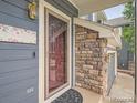 Welcoming front door with sidelight, stone accents, and blue siding at 9865 Centre Cir, Parker, CO 80134