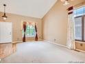 Bright living room featuring large windows, neutral carpet, and a vaulted ceiling at 9865 Centre Cir, Parker, CO 80134