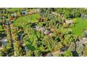 Aerial view of large property with tennis court surrounded by mature trees and landscaping at 1700 E Tufts Ave, Cherry Hills Village, CO 80113