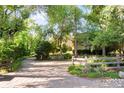 Long driveway with stone pavers, wooden fence, and mature landscaping at 1700 E Tufts Ave, Cherry Hills Village, CO 80113