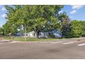 View of home with mature trees, green lawn, and chain link fence on a corner lot at 2105 S Irving St, Denver, CO 80219
