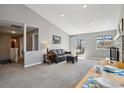 Cozy living room featuring carpeted floors, a modern sofa, a stone fireplace, and access to the backyard at 9532 W Walden Ave, Littleton, CO 80128