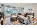 Inviting living room featuring hardwood floors, a large window with ample natural light, and comfortable furnishings at 9580 W 12Th Pl, Lakewood, CO 80215